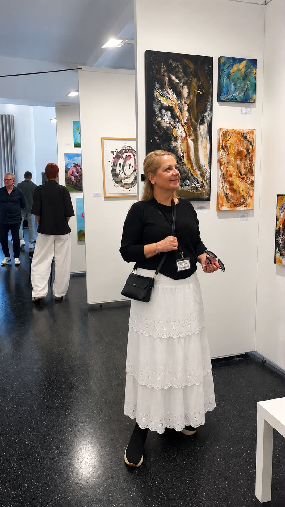 Ildik&oacute; Simon in front of her paintings at the exhibition